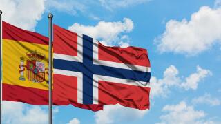 Spain and Norway flag waving in the wind against white cloudy blue sky together. Diplomacy concept, international relations.