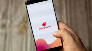 A mobile phone or cell phone being held by a hand with the Express VPN app open on screen