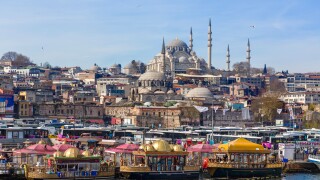 Decorative boats selling fish sandwiches (Tarihi Eminonu Balik Ekmek) with Suleymaniye Mosque behind, Eminonu, Istanbul, Turkey