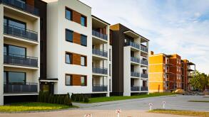 New multi-family block with balconies and bright facade decorated with wood paneling.