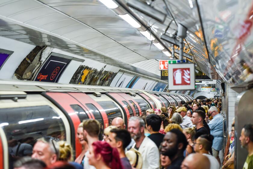 Crowded London Underground station platform and train, Tottenham Court Road tube station busy with passengers at peak time. Packed