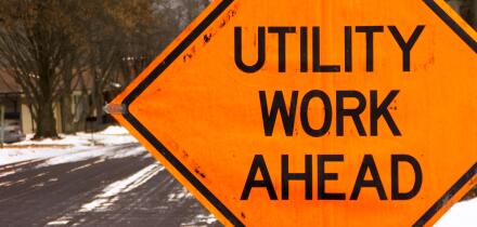 Utility work ahead road construction warning sign.