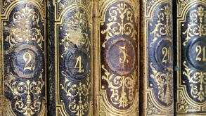 Vintage ornate book spines with intricate gold designs and numbers.