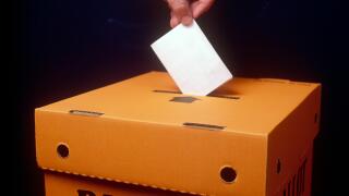 Voting paper being placed into a Ballot box, inside.