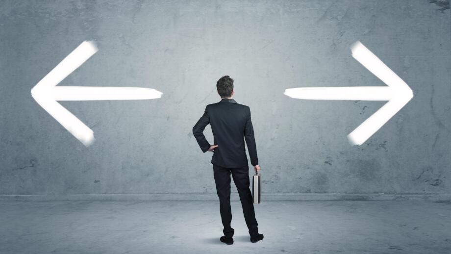 A businessman in doubt, having to shoose between two different choices indicated by arrows pointing in opposite direction concept