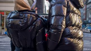 Pedestrians in Chelsea in New York wear Moncler brand parkas on Thursday, December 23, 2021  (© Richard B. Levine)