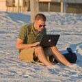 Doing work on computer on the beach
