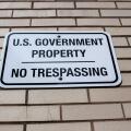 Annapolis, MD 08/21/2020: A white metal plate attached to a brick wall encircling a government building in Annapolis. The sign reads: 'U.S Government