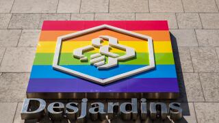 Montreal, Canada - August 6, 2019: Desjardins Credit Unions sign on headquarter building exterior wall with rainbow flag. Landscape format