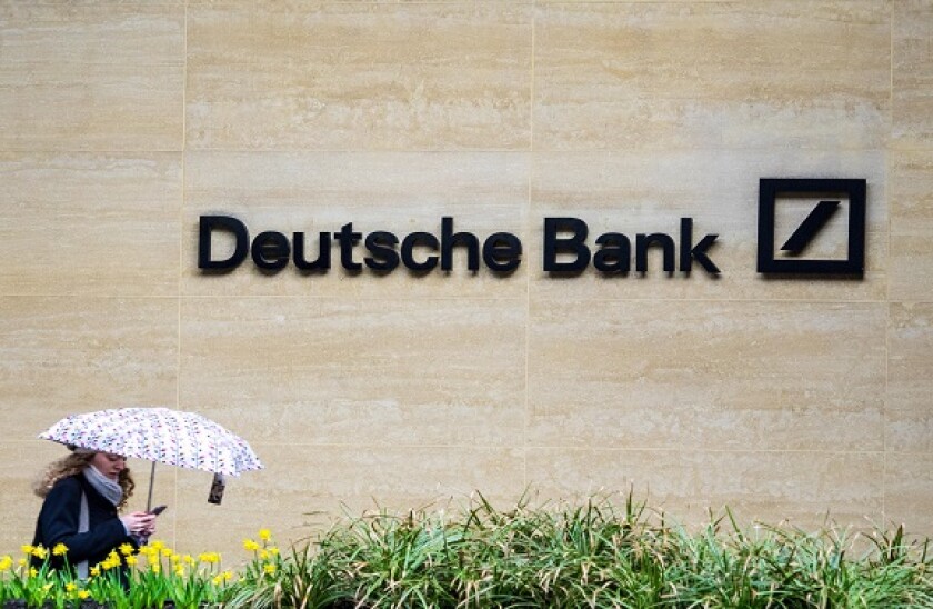 Deutsche Bank London - a woman walk past the London offices of Deutsche Bank in the Square Mile, London's Financial District.