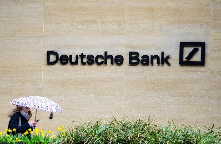 Deutsche Bank London - a woman walk past the London offices of Deutsche Bank in the Square Mile, London's Financial District.