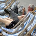 A man reading the "Racing Post" newspaper while sitting in a deck chair on the sea front at Weymouth UK. Image shot 2007. Exact date unknown.