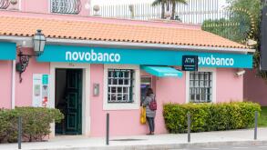 Customer using atm of novo banco, a portuguese bank, for financial transactions