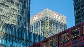 Canary Wharf skyscrapers including Citigroup HQ building (Citi sign and logo) with a DLR Docklands Light Railway train, East London, England, UK