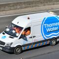 Hard hats & team of workers wear workmen's high visibility safety jackets traveling to work Thames Water logo on side of Mercedes van on UK motorway