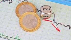 Downtrend financial market chart, red arrow, dices cube with the word STOP and one-euro coins. Selective focus