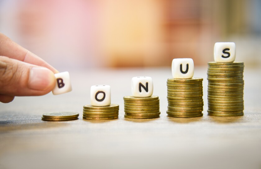 Yearly Bonus concept / hand holding words of bonus on stack coin