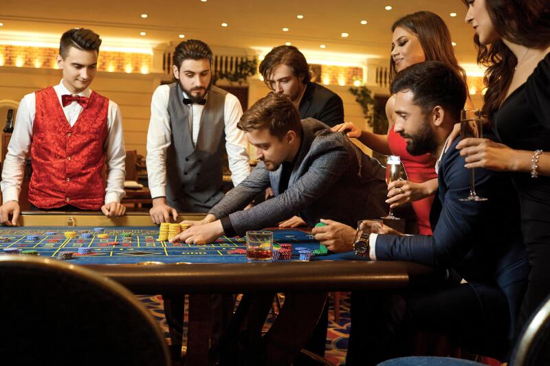 A group of people playing gambling in a casino.