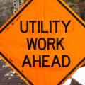 Utility work ahead road construction warning sign.