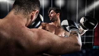 Boxer punches his opponent during boxing competition