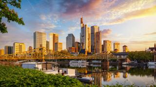 Golden sunrise view of the skyline of Frankfurt am Main, Germany, with banking skyscrapers, Eiserner Steg Bridge and River