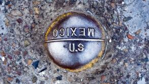 US-Mexico border marker in the road at the San Ysidro, San Diego crossing. Law enforcement agencies have found numerous tunnels along the boarder used for drugs trafficking. See description for more information