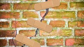 Renovation of an old cracked brick wall - concept image with bandaid patch