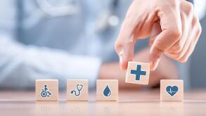 Hand arranging wood block with healthcare medical icon. Health insurance - concept.