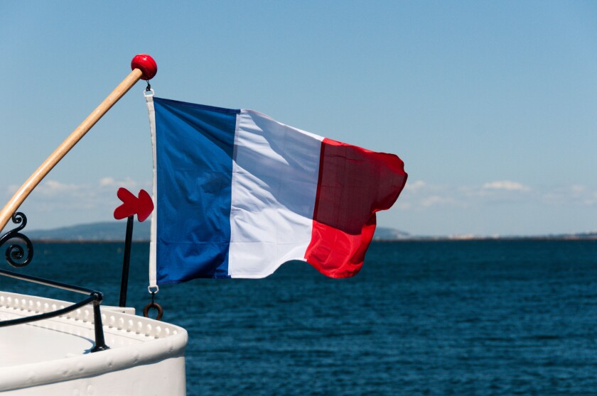 The French flag or Tricolour flying from the stern of a boat.