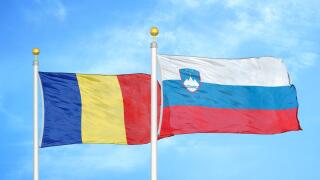 Romania and Slovenia two flags on flagpoles and blue sky