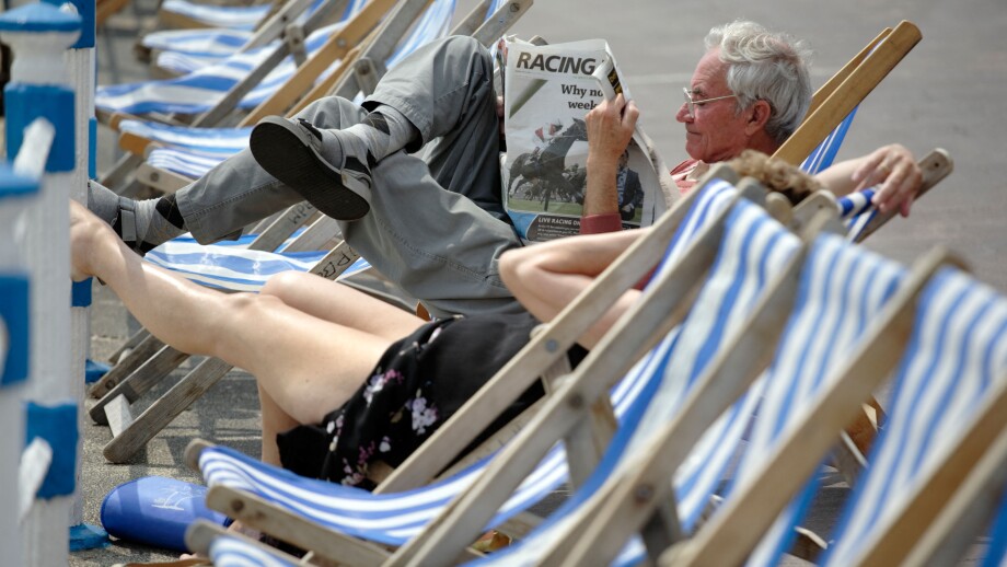 A man reading the "Racing Post" newspaper while sitting in a deck chair on the sea front at Weymouth UK. Image shot 2007. Exact date unknown.