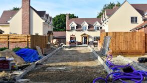 Building site for small new housing property development nearing completion with kerbs garden fences and road foundations in progress Essex England UK
