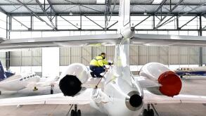 Airport workers check an aircraft for safety in a hangar