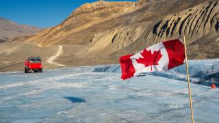 Canadian flag and Ice explorer vehicle on Athabasca glacier of Columbia Icefield, Jasper National Park, Alberta, Canada.