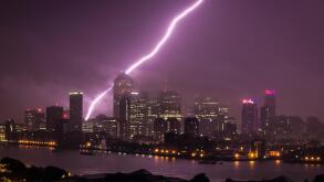 Massive Lightning strike just behind Canary Wharf business park buildings and River Thames in London, UK.