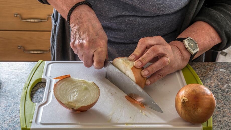 Woman chopping onions to make chutney.