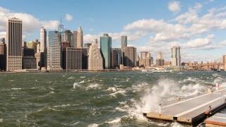 The windy, choppy waters of the East River break against a breakwater in Brooklyn Bridge Park in New York on Sunday, October 23, 2016. Wind gusts reached 55 mph with the city issuing a wind advisory. Monday is expected to be warmer with less wind. (© Rich