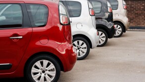 row of new cars for retail sale in a motor dealer yard showing same model in different color choices