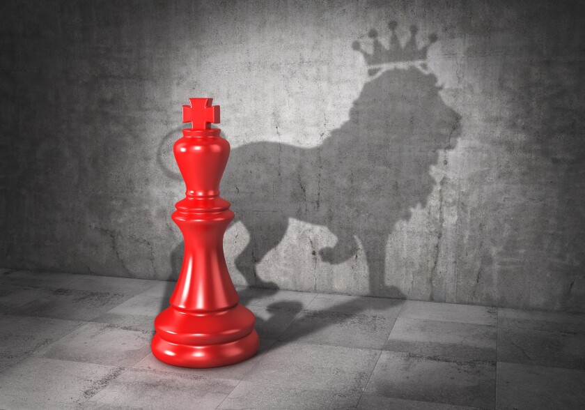 Leader concept. Headman. Chess king cast shadow in form of lion 