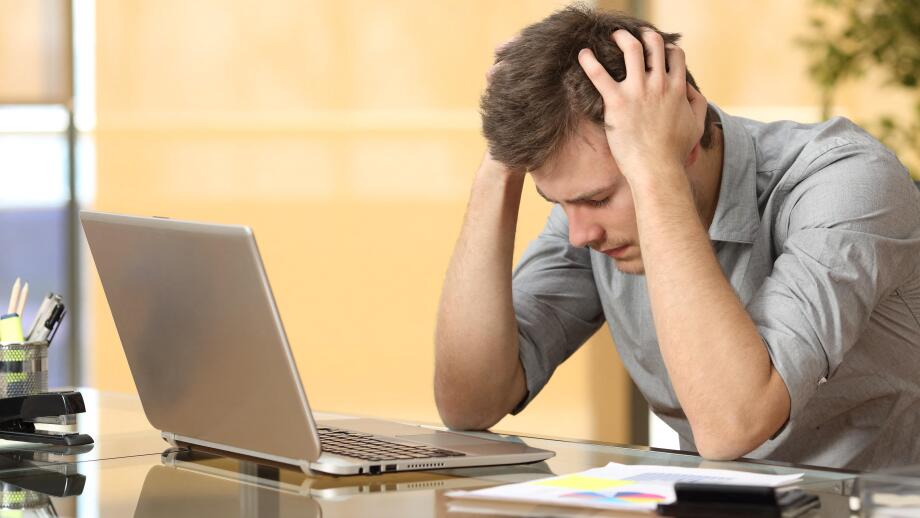 Worried businessman lamenting in front of a computer after a big mistake at office