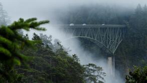 Cars on end of bridge still visible as mist settles over mountain gorge in Seattle
