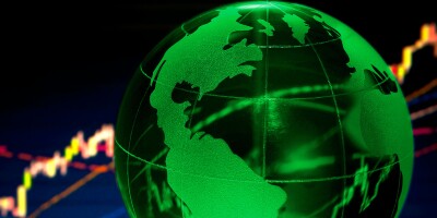 Glass globe over stock data on computer screen