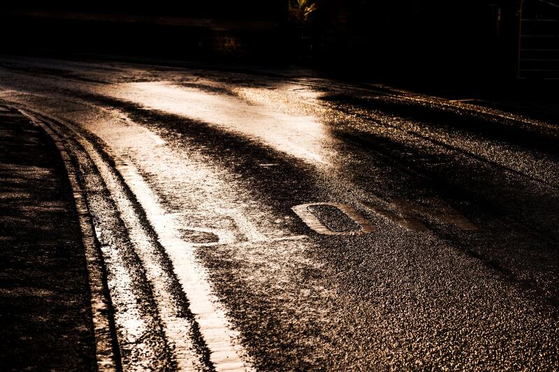 Slow sign painted on a road in Bugbrooke, Northamptonshire in low winter sun light