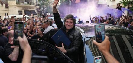 Argentine President Javier Milei waves to supporters upon arriving at a hotel in Rosario, Argentina, Thursday, Oct. 23, 2025. (AP Photo/Rodrigo Abd)