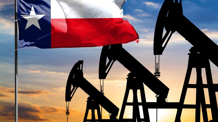 Oil rigs against the backdrop of the colorful sky and a flagpole with the flag State of Texas. The concept of oil production, minerals, development of