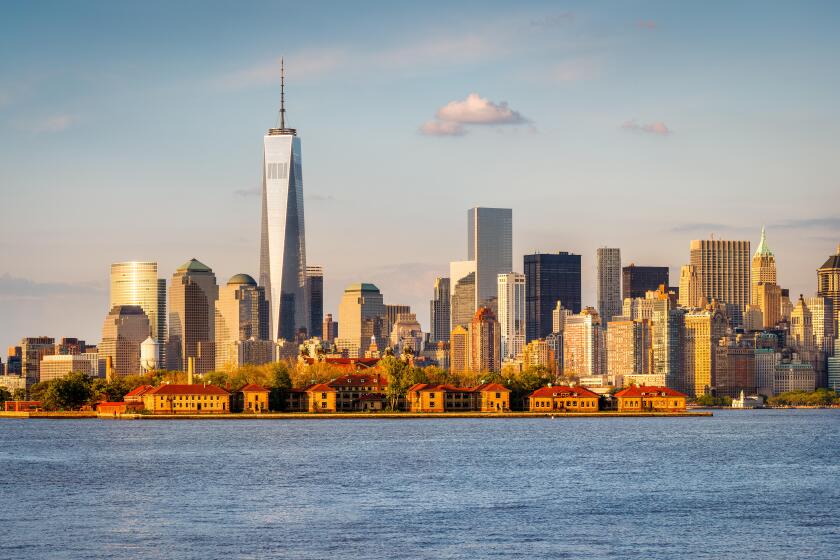 New York Harbor view of the World Trade Center and Lower Manhattan with Financial District skyscrapers and Ellis Island. USA