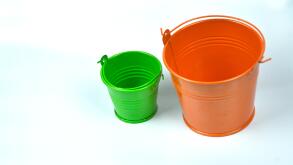 Small orange and green buckets isolated on white background.