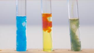 Three test tubes containing (left to right) precipitate of copper hydroxide, precipitate of iron (III) hydroxide and precipitate of iron (II) hydroxid