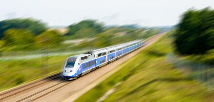 A double-decker TGV Duplex high speed train in Atlantic livery from french company SNCF driving at full speed in the countryside (with motion blur).