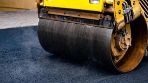 Compact steamroller flatten out the asphalt.